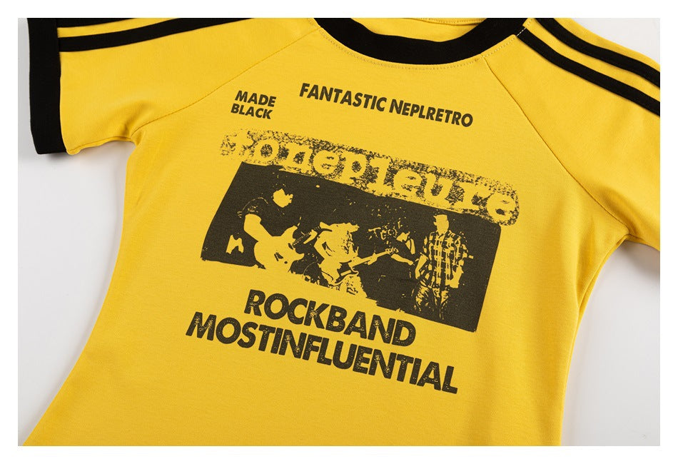 Close view of a yellow shirt front with black trim and distressed black rock-band graphic and text.
