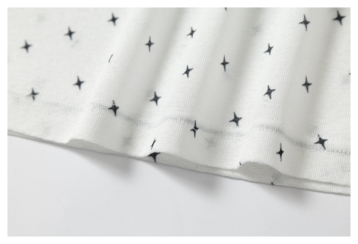 Close-up of the stitched hem on white fabric with a small black star print.