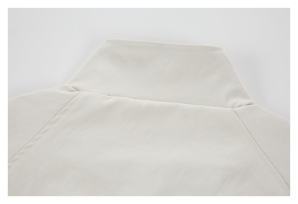 Close-up of the back collar and shoulder seams of a pale beige garment.