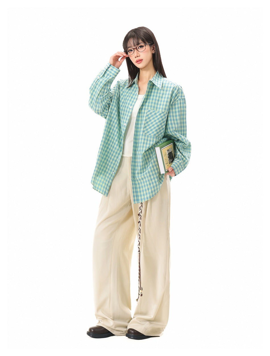 Full-length model wearing an oversized teal and pale yellow gingham shirt with cream wide-leg trousers.