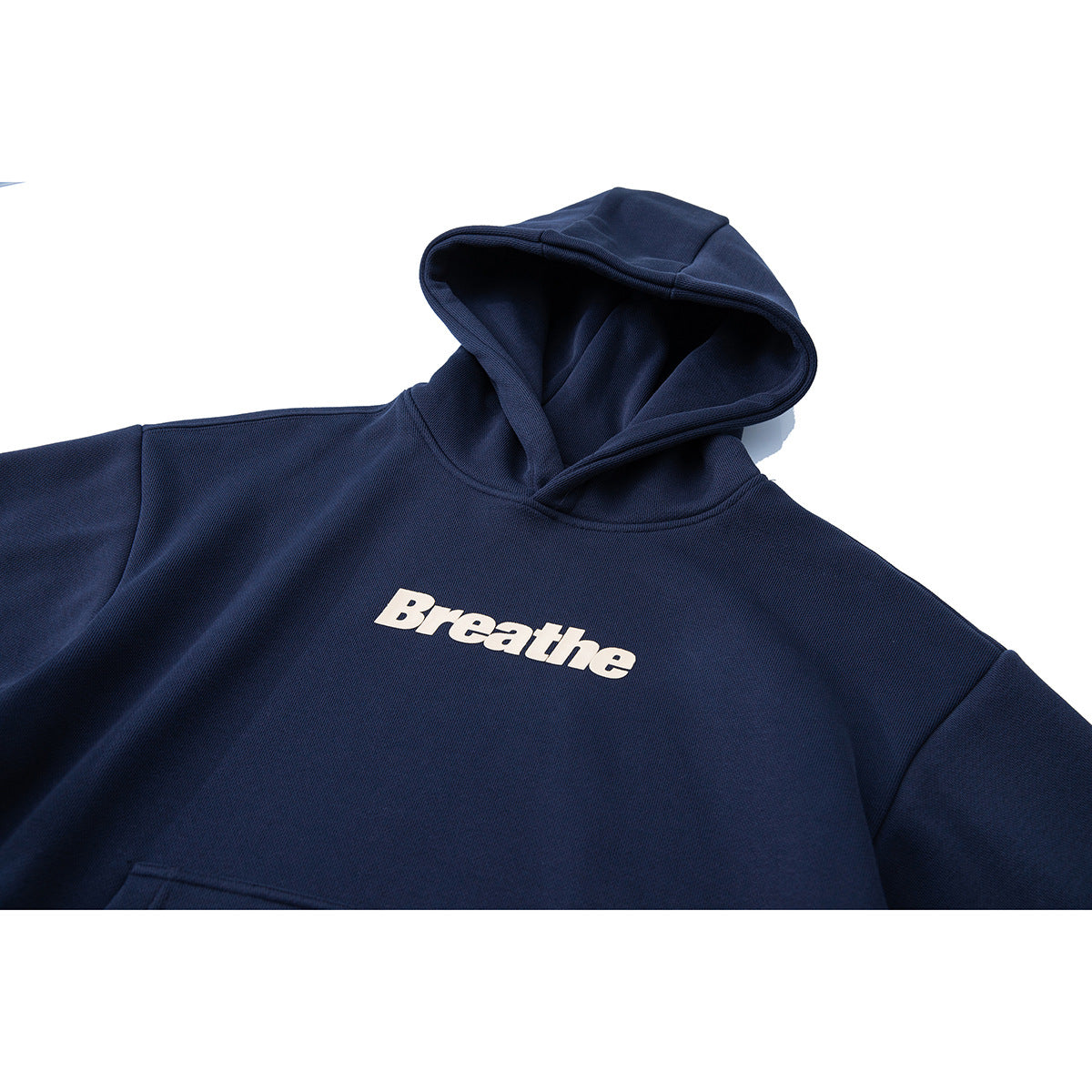 Close-up of a navy pullover hoodie with a white “Breathe” chest print and an oversized hood.