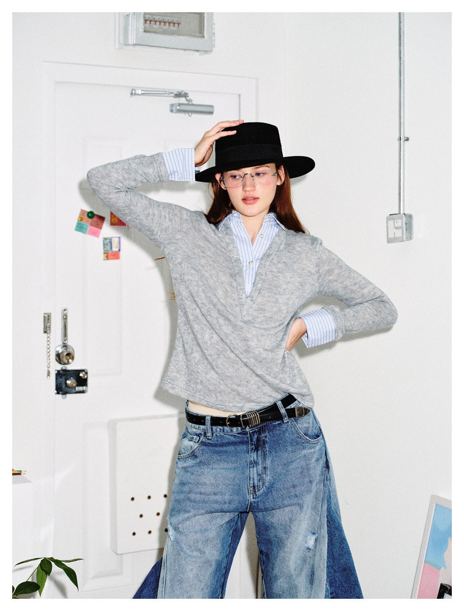 Model in gray deep V-neck top with striped shirt collar and cuffs, black hat, glasses and wide-leg jeans