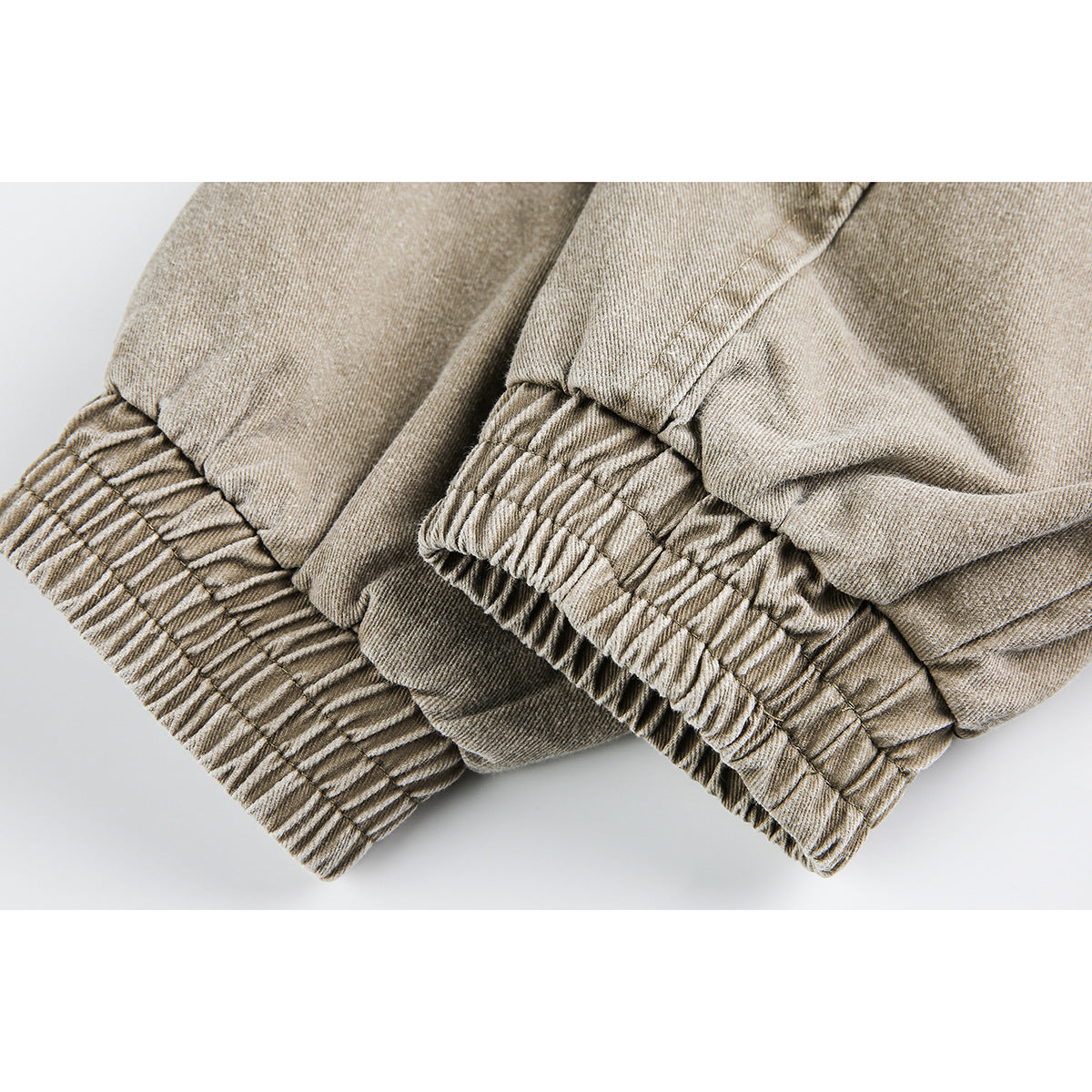 Close-up of gathered elastic cuffs on a tan jacket sleeve.