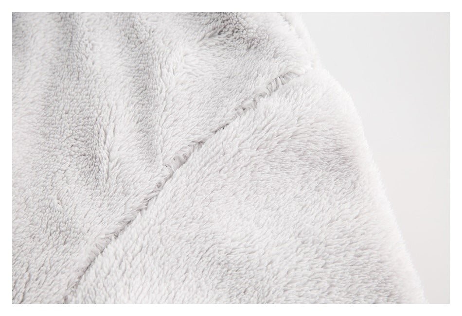 Close-up of pale gray plush fabric with a diagonal stitched seam.