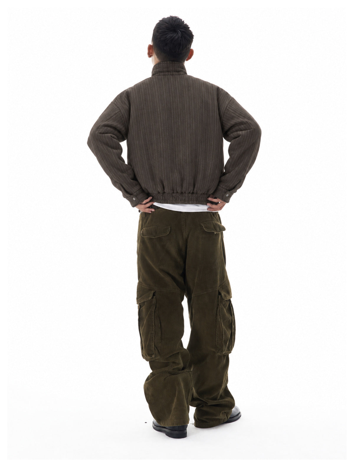 Rear view of a model wearing a dark brown pinstripe jacket and olive cargo pants.