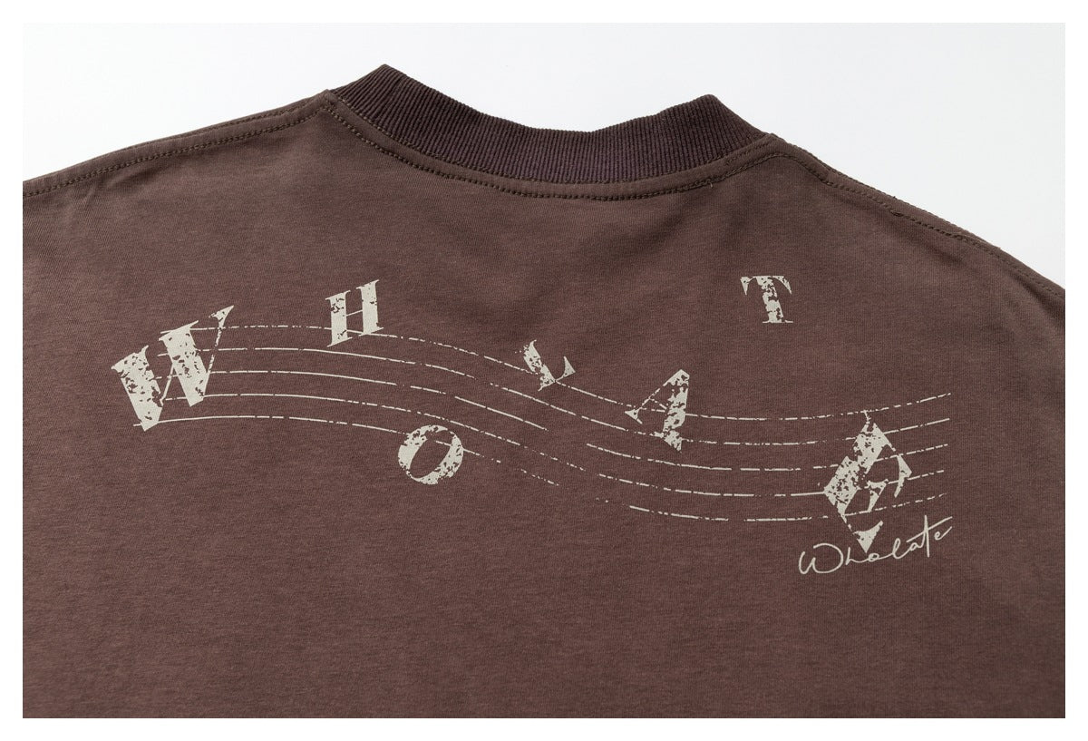 Close-up of the brown T-shirt back with distressed cream lettering arranged along curved lines.
