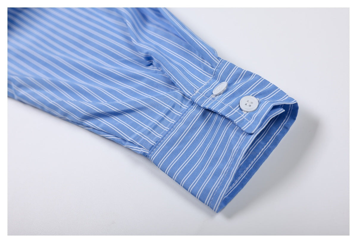 Close-up of a blue-and-white striped shirt sleeve cuff with two white buttons.