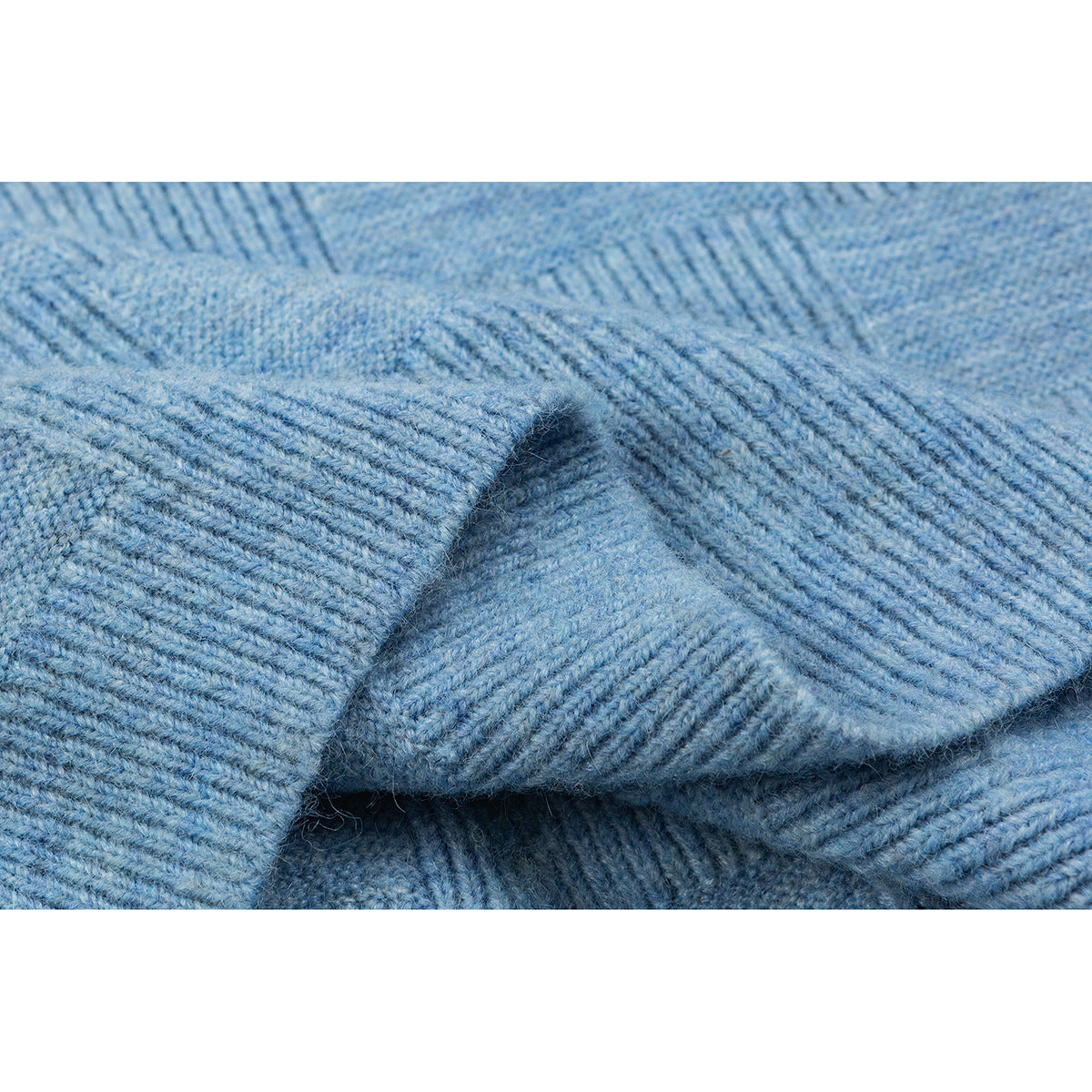 Close-up of folded blue knit fabric showing its raised ribbed texture and edge.