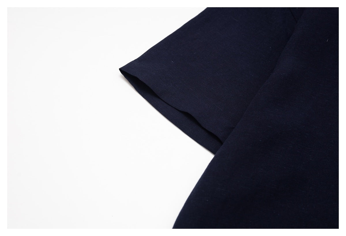Close-up of a dark navy shirt sleeve and stitched seam against a white background.