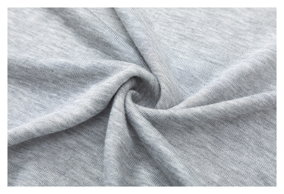 Macro view of light gray heather knit fabric gathered into a spiral.