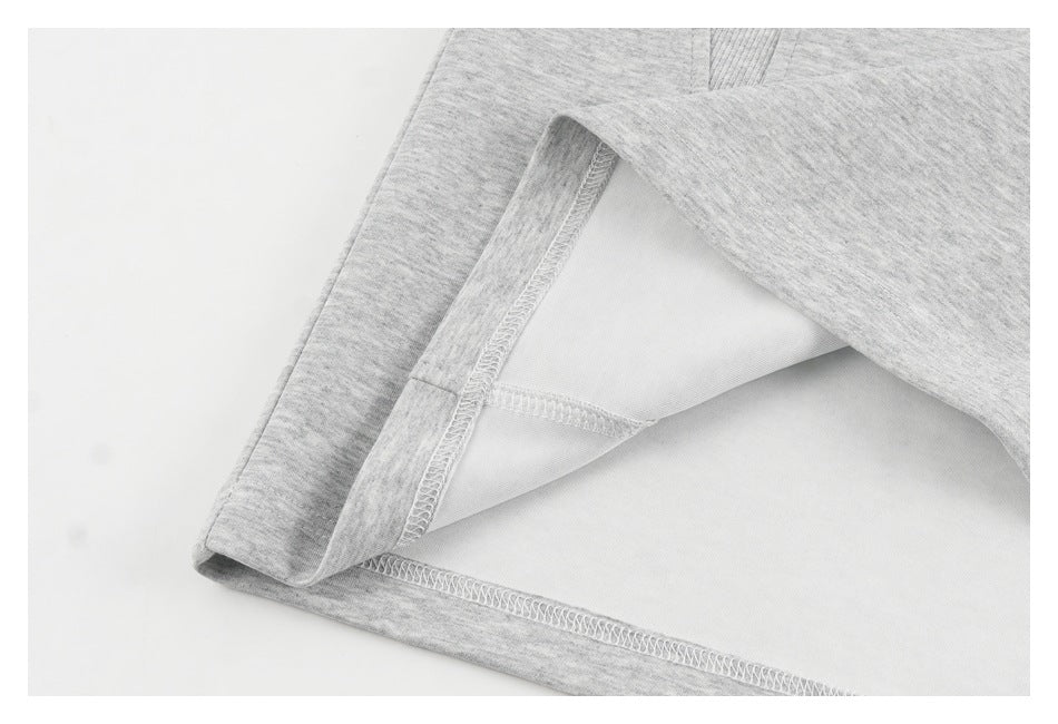 Close-up of the inside of a heather-gray garment, showing overlocked seams and a folded edge.