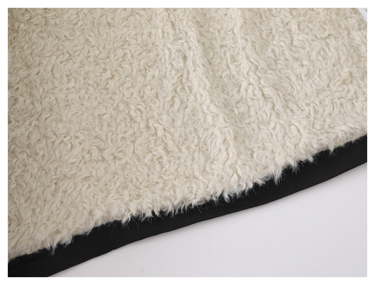 Close-up of the coat's thick, curly white lining against its black outer fabric.