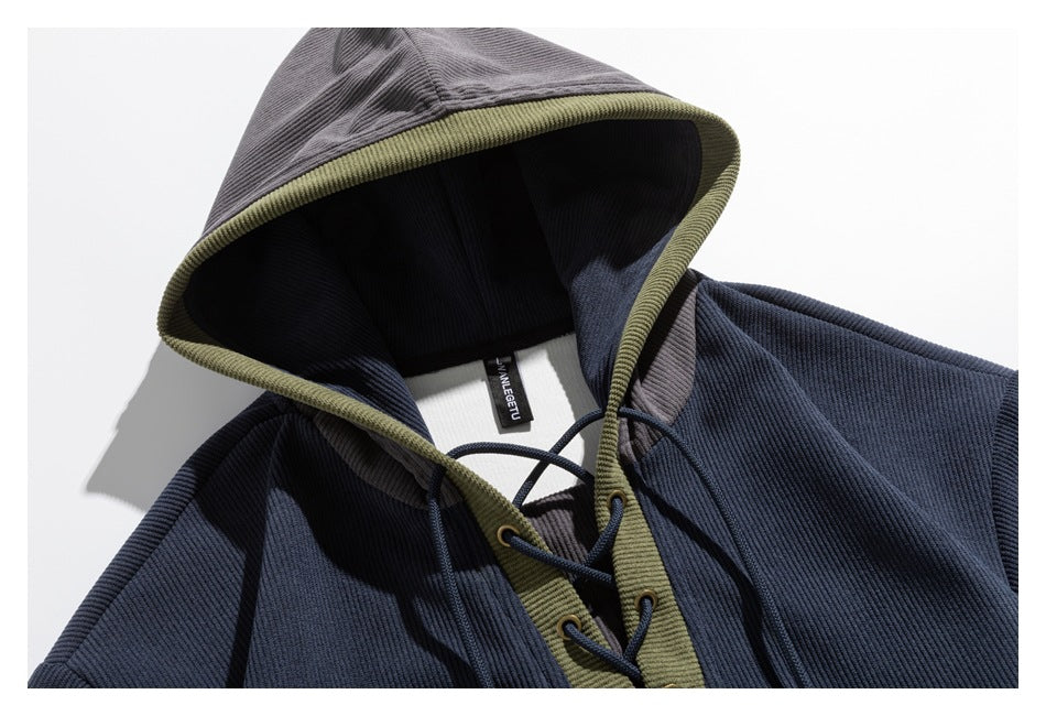 Close-up of a navy hood with olive edging and drawcord lacing at the neckline.
