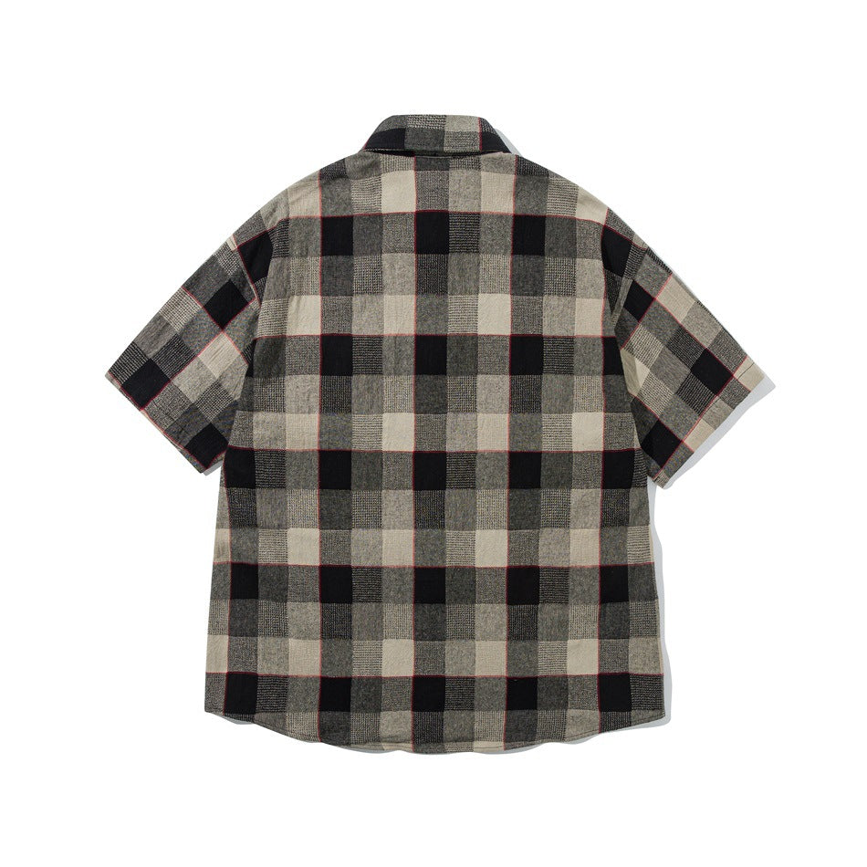 Back view of a short-sleeve shirt in beige, gray, and black checks with thin red lines.