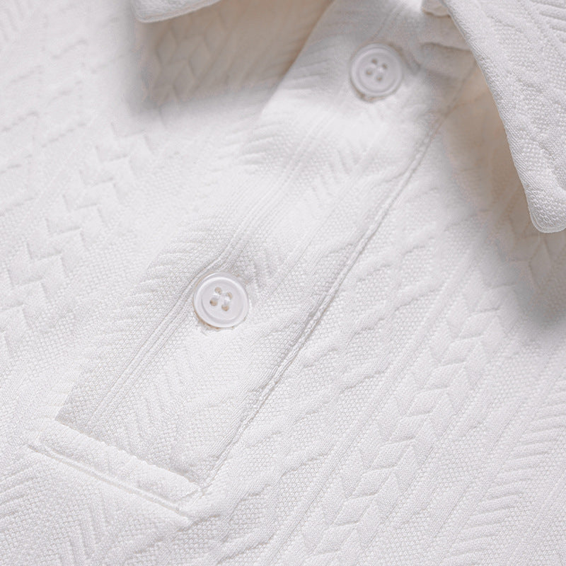 Close-up of a white polo shirt's button placket and textured geometric pattern.