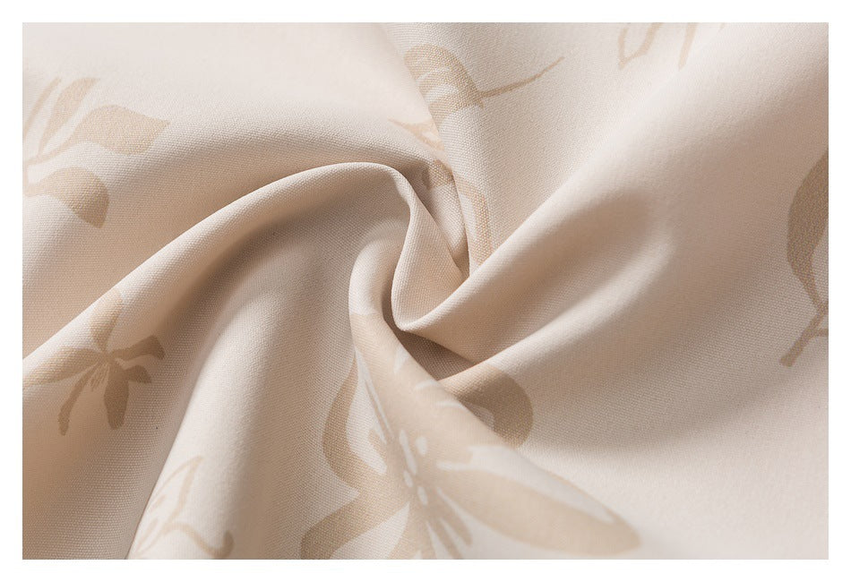 Close-up of softly draped cream fabric with a subtle beige floral print.