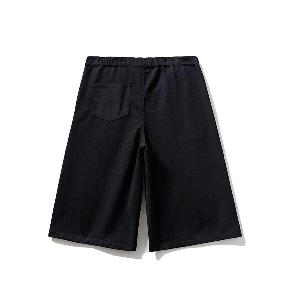 Back view of black knee-length shorts with elastic waistband and a single patch pocket