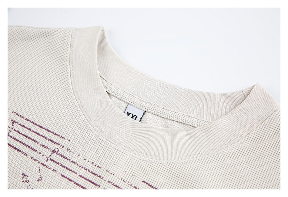 Close-up of an off-white textured shirt with a ribbed crew neckline and a partial burgundy graphic.