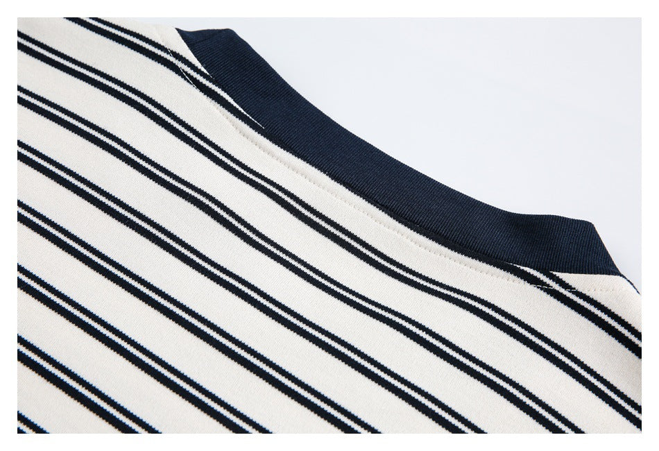 Close-up of a dark navy ribbed collar on an ivory garment with black stripes.