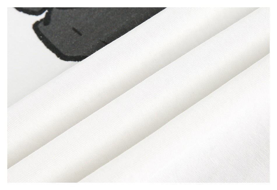 Close-up of white fabric folds with part of a black printed graphic visible.