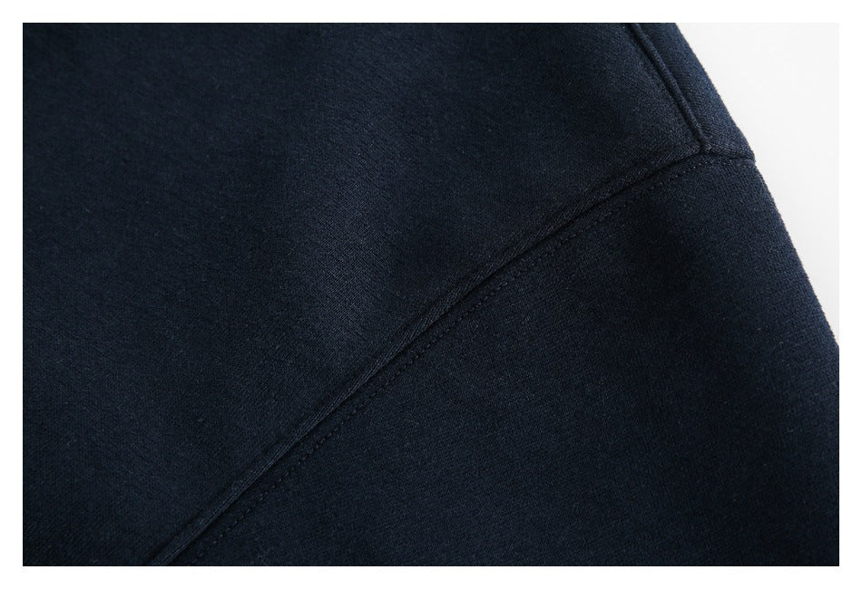 Close-up of a seam joining two sections of dark navy sweater fabric.
