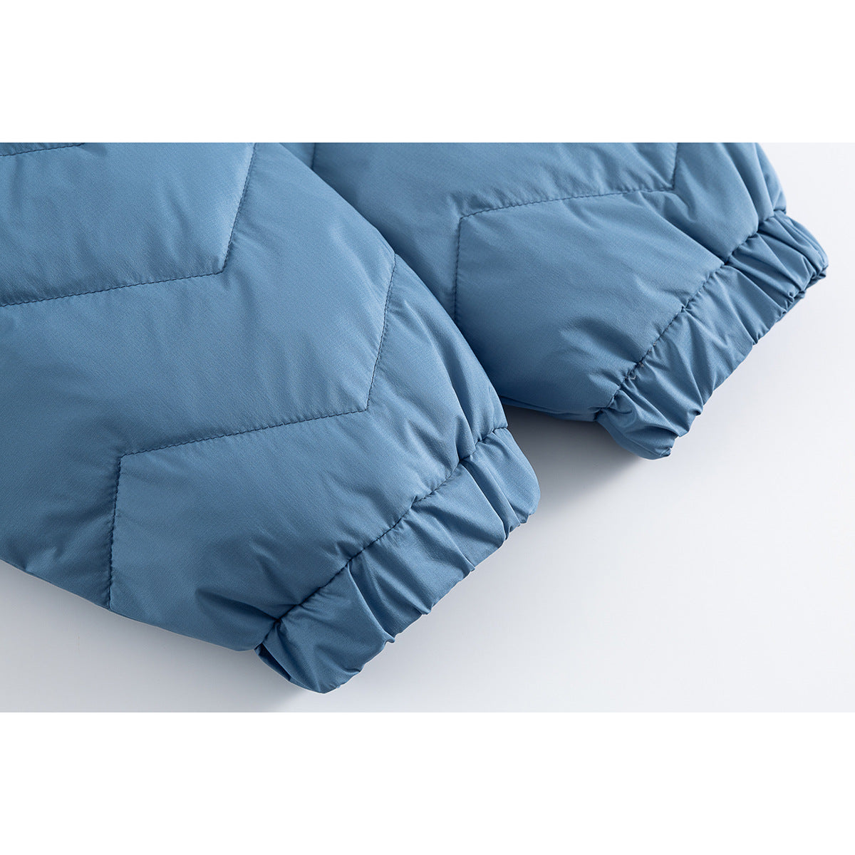 Close-up of the blue jacket's quilted lower sleeve and gathered elastic cuff.