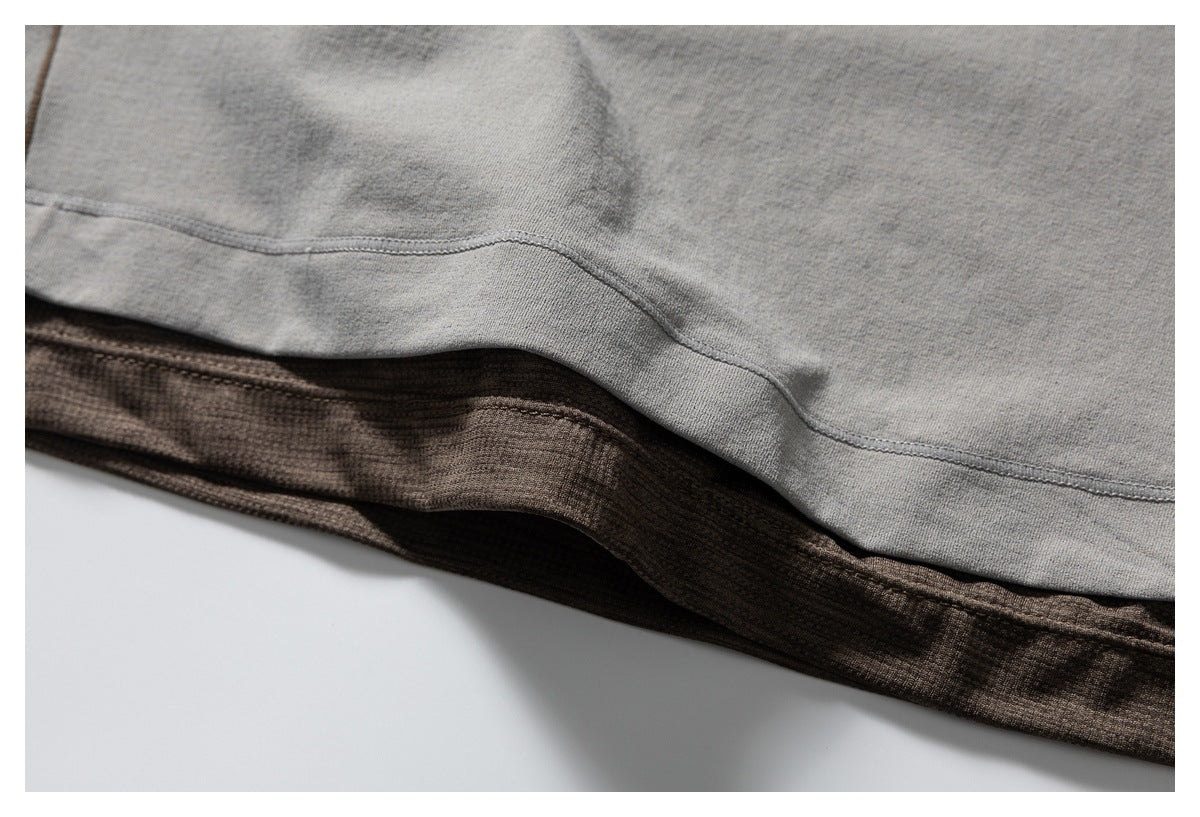 Close-up of a gray garment hem layered over a brown fabric hem.