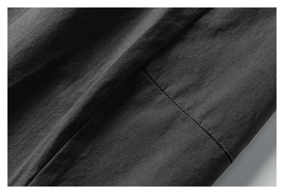 Close-up of dark garment fabric with a diagonal stitched seam.