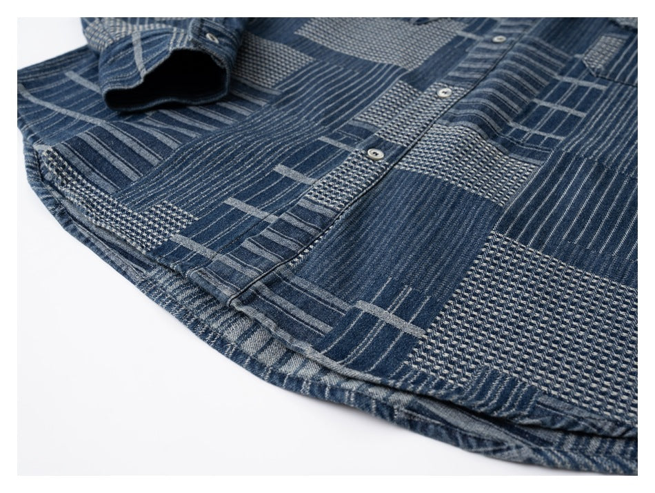 Close-up of a dark blue patchwork-pattern shirt showing the button placket, chest pocket, and cuff.