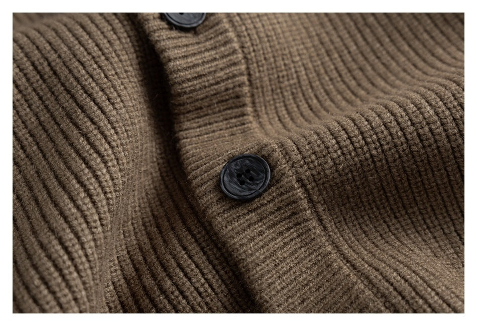 Close-up of a brown rib-knit cardigan with dark buttons along the front placket.