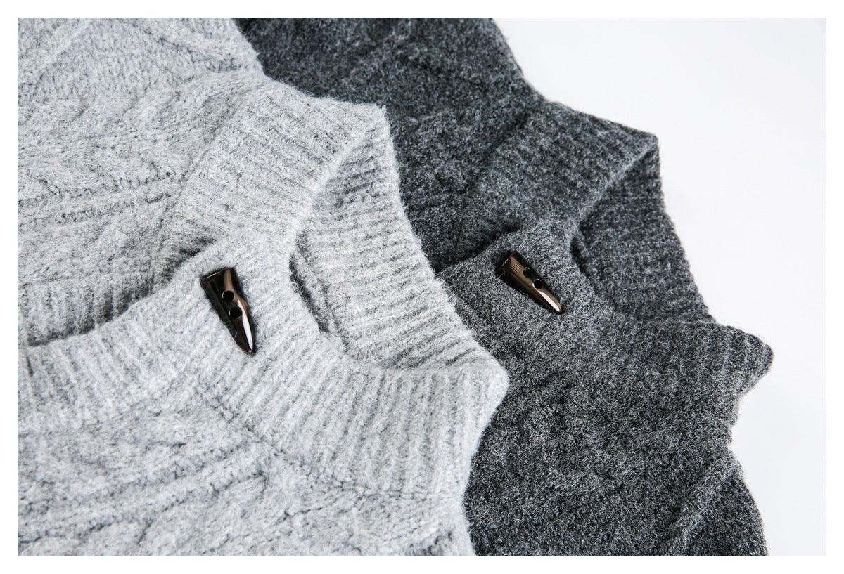 Close-up of light gray and charcoal cable-knit sweaters, showing ribbed collar edges and dark toggle buttons.