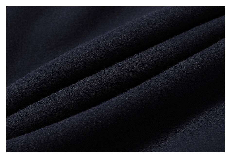 Close-up of dark navy fabric arranged in soft diagonal folds, showing its fine textured surface.