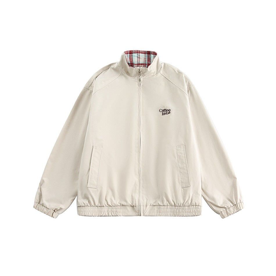 Apricot zip-up stand-collar jacket flat lay with chest logo, front pockets, elastic cuffs and hem, red plaid collar lining