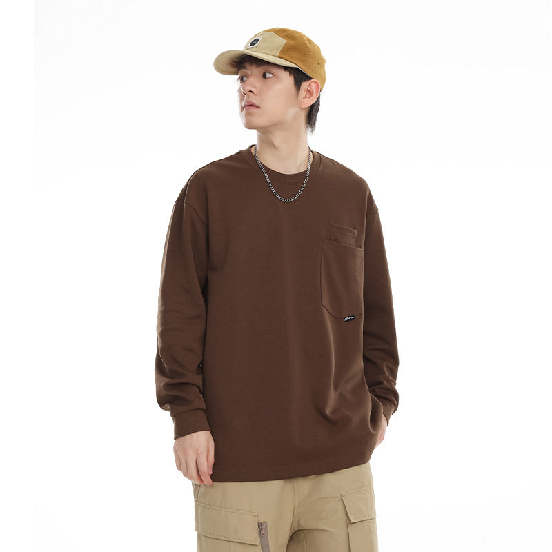 Model wearing a brown long-sleeve crewneck shirt with a chest pocket and tan cap.