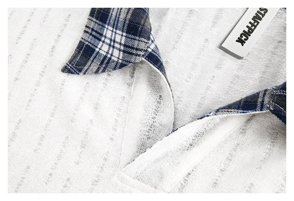 Close-up of the white textured fabric, navy plaid collar, and inner garment label.