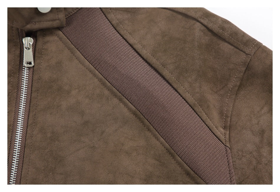 Close-up of the brown jacket's front zipper, shoulder seam, and diagonal dark trim.