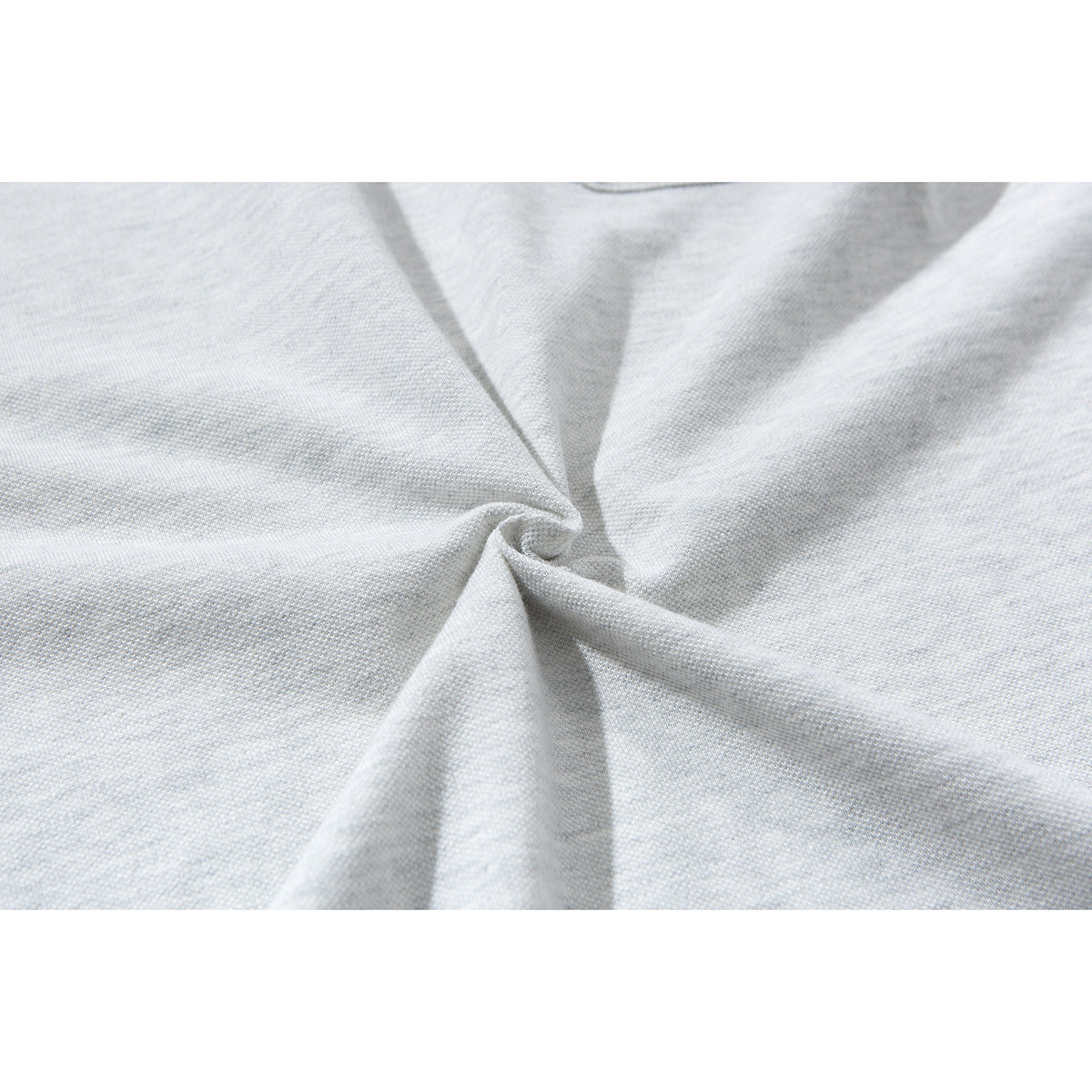 Close-up of light gray polo fabric gathered into folds to show its surface texture.
