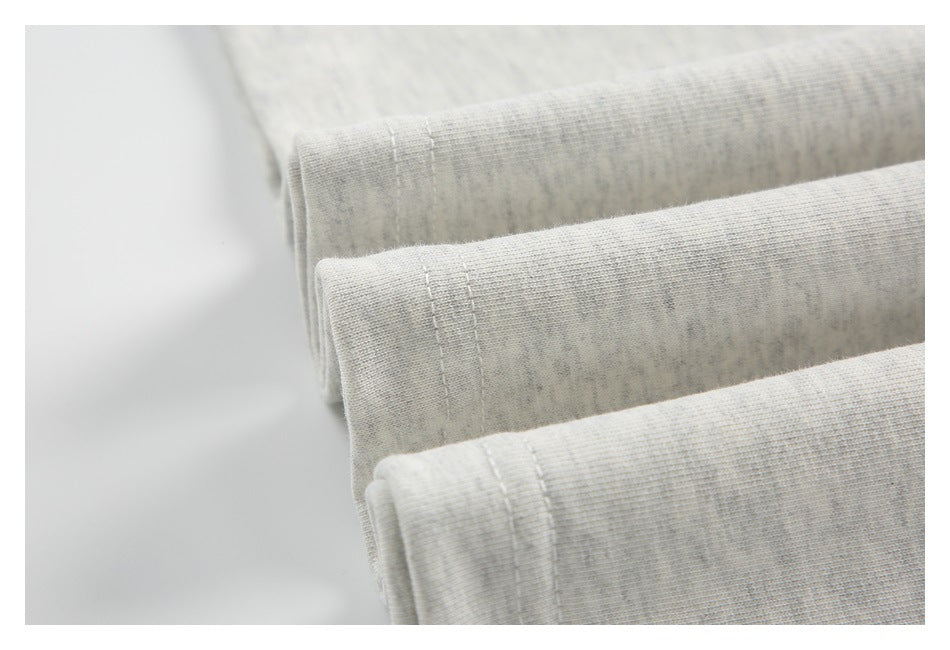 Close-up of folded light heather-gray fabric with stitched edges.