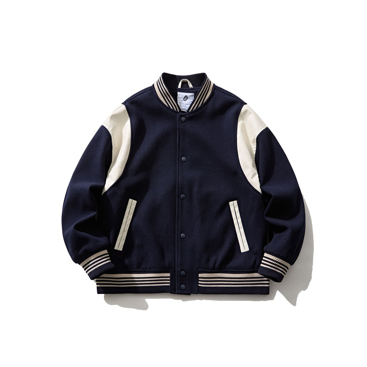 Navy varsity baseball jacket with cream shoulder panels, striped ribbed trim and snap-button front, flat view