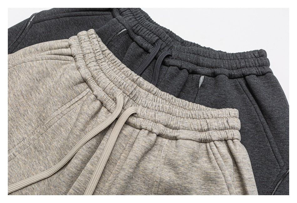 Close-up of light gray and charcoal shorts showing elastic waistbands, drawstrings, and front pockets.