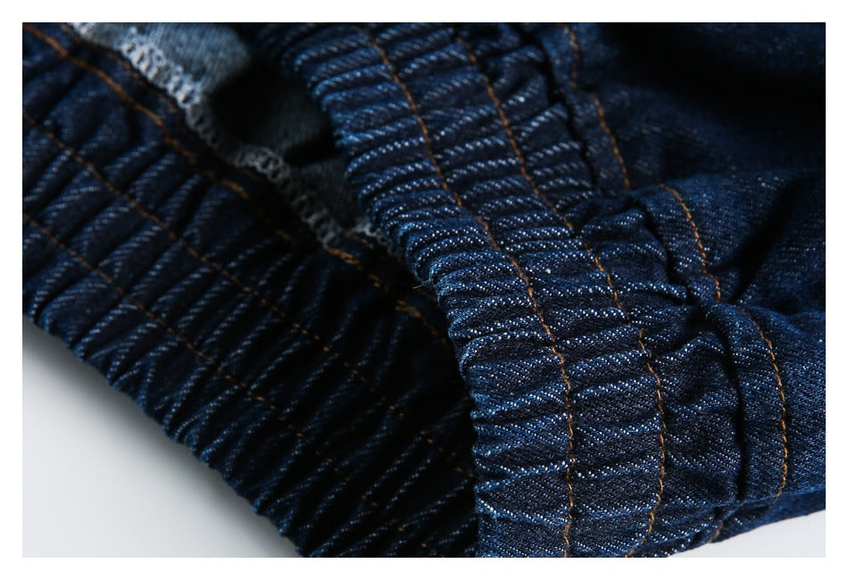 Close-up of gathered dark indigo denim with stitched seams and a folded edge.