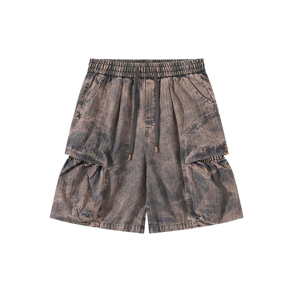 Front of grey-brown washed cargo shorts with drawstring waist, side cargo panels and gathered lower pockets