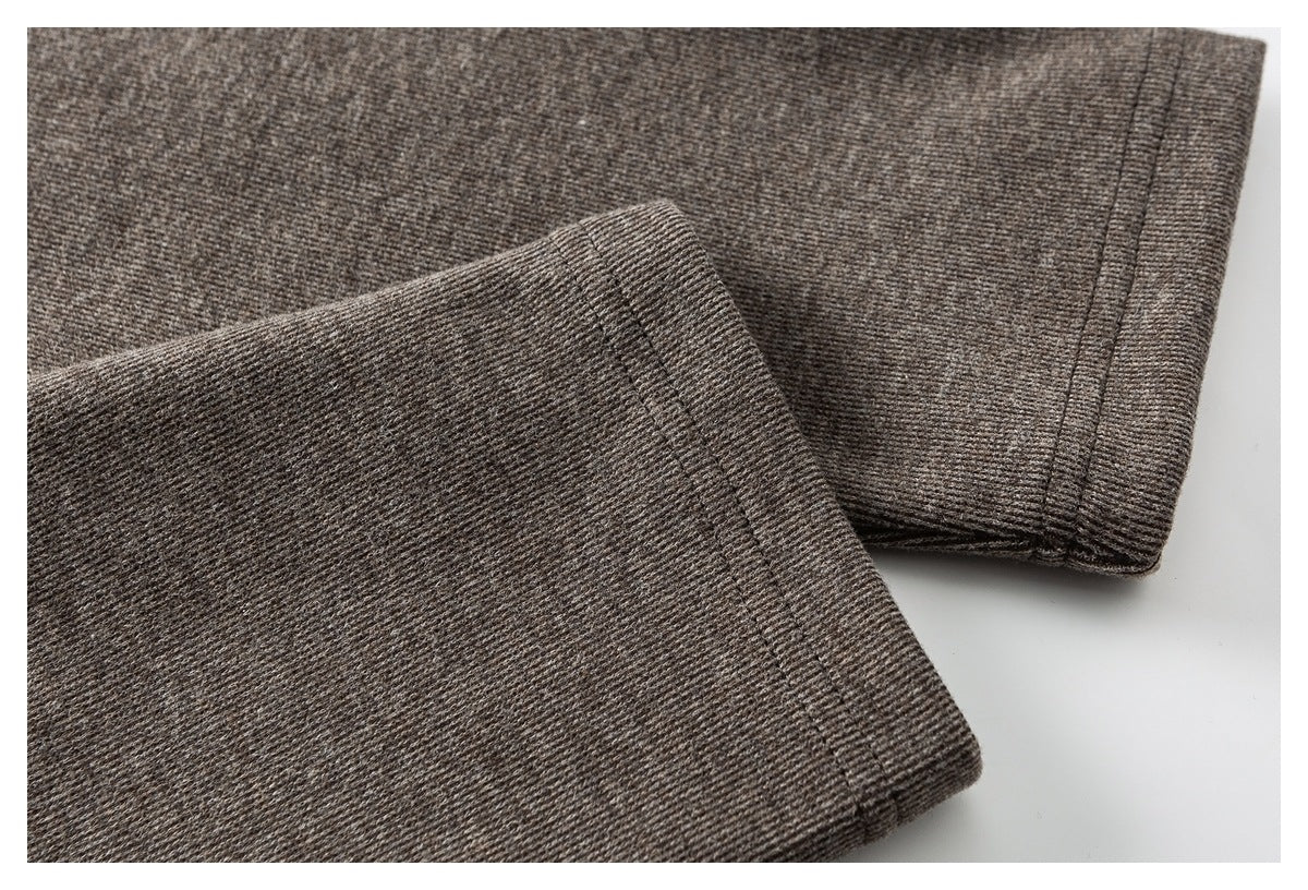 Close-up of brown knit garment with a folded, stitched edge and visible fabric texture.