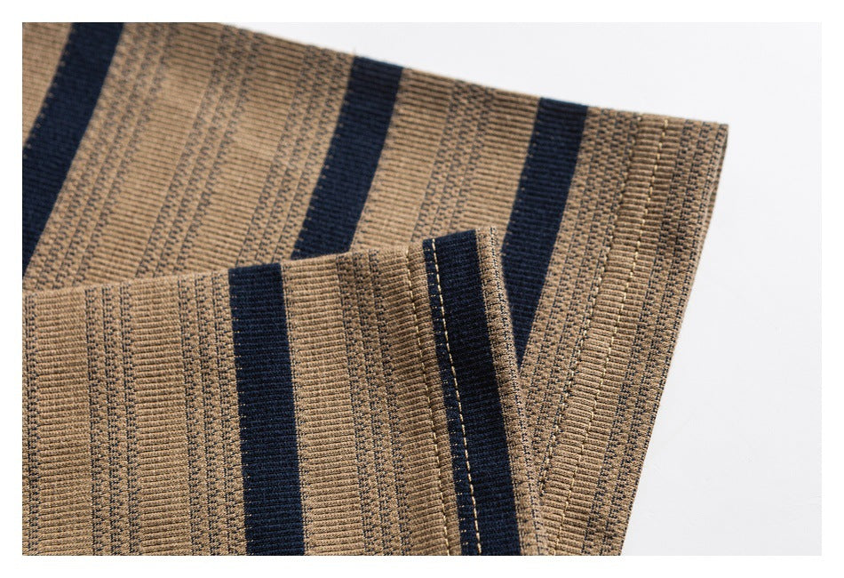 Close-up of tan knit fabric with navy stripes and a folded, stitched edge.