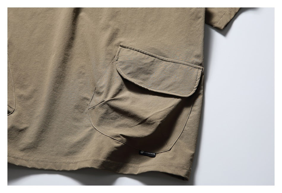 Close-up of a large flap pocket and hem on the taupe top.