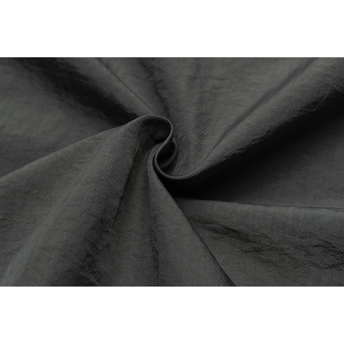 Close-up of charcoal-gray fabric gathered into folds, showing its fine surface texture.
