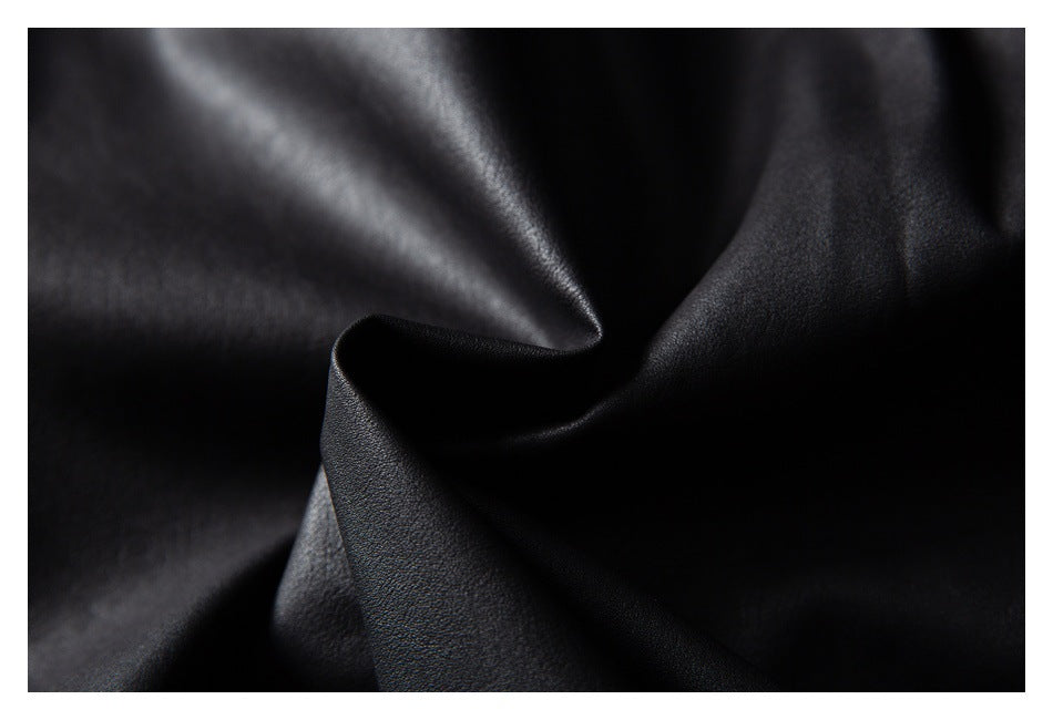Close-up of folded black garment fabric showing its reflective surface and fine texture.