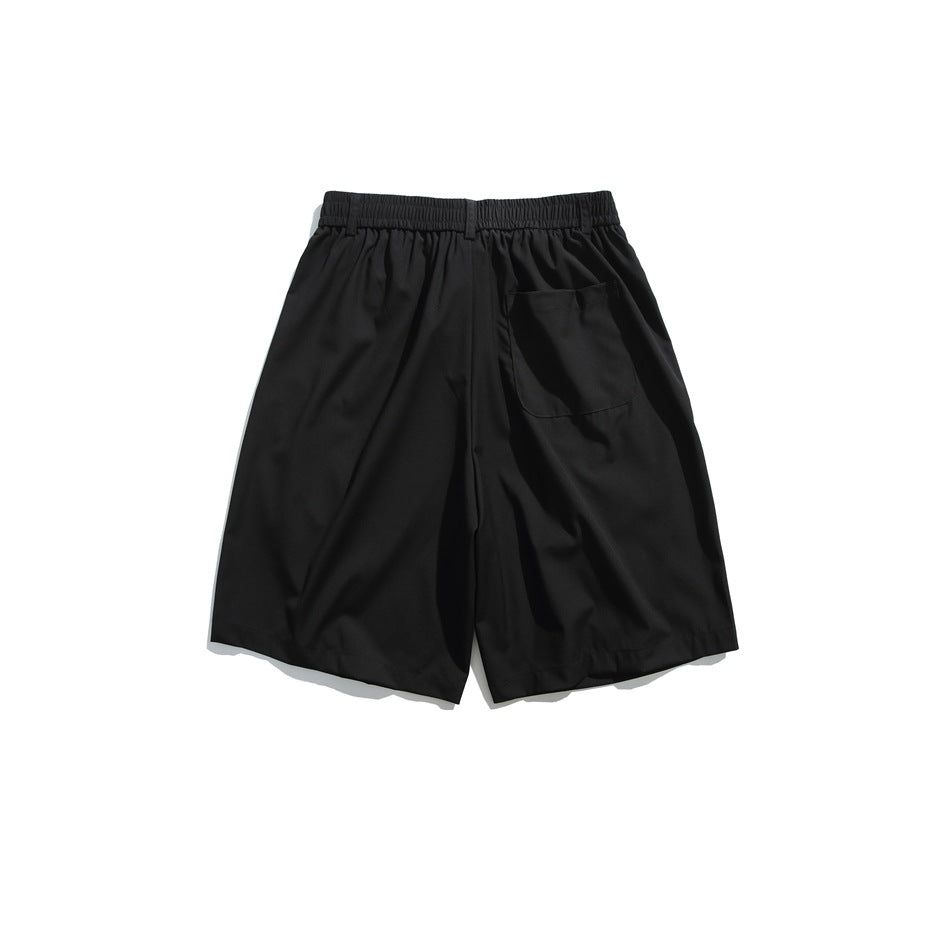 Back view of black knee-length shorts with elastic waistband and one patch pocket