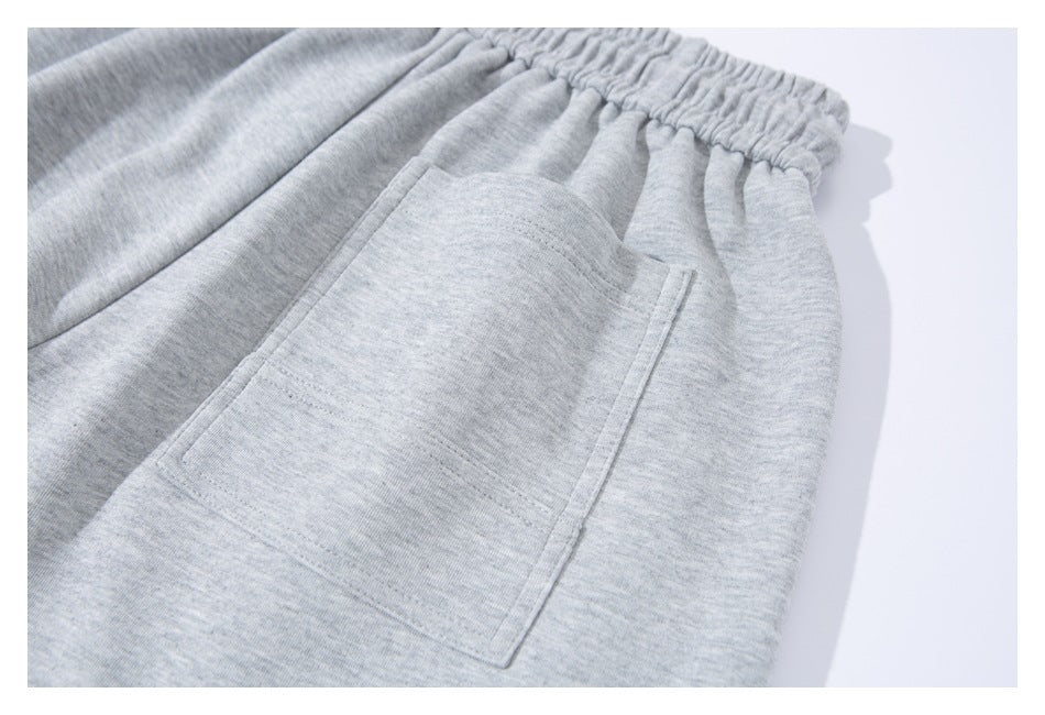 Close-up of a large patch pocket on light gray sweatpants.