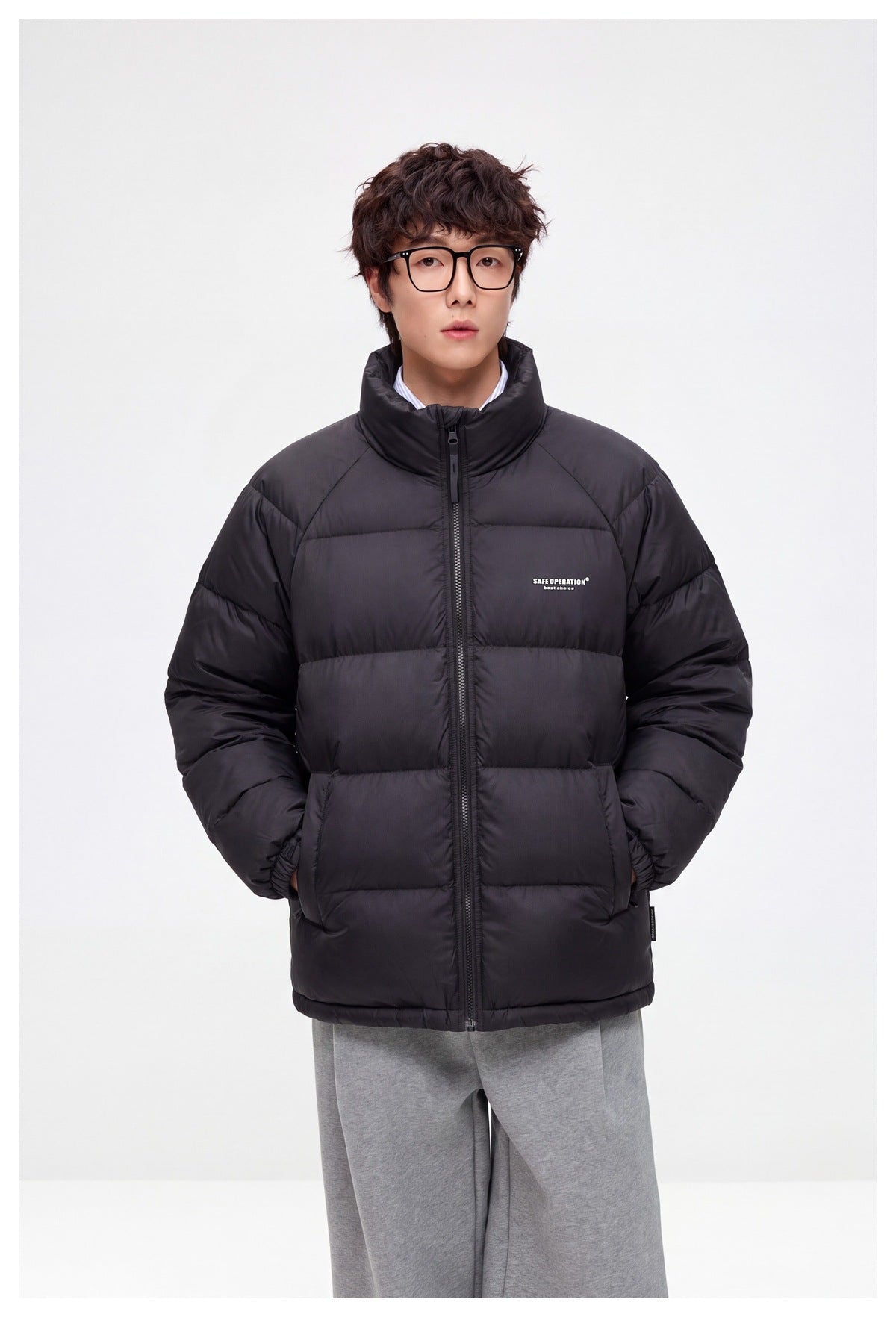 Front view of a model wearing a black quilted puffer jacket with a high collar and front zipper.